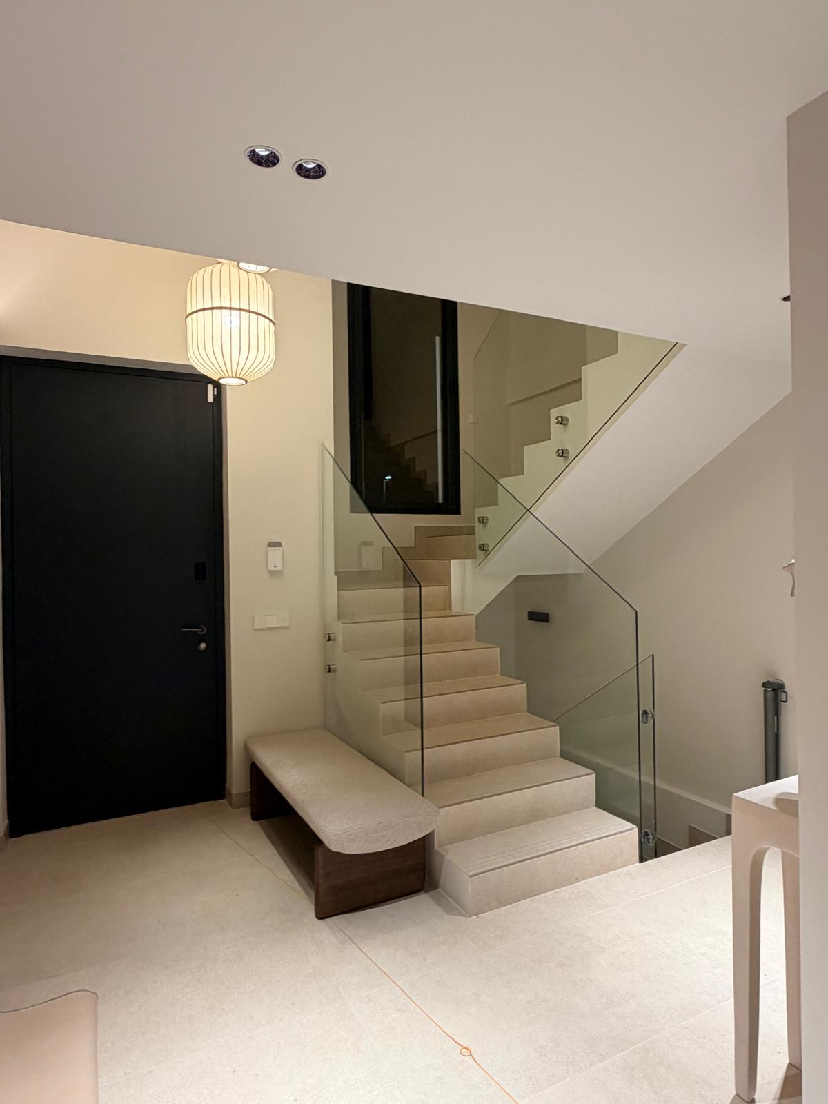 Entrance hall with glass balustrade staircase in a completed villa